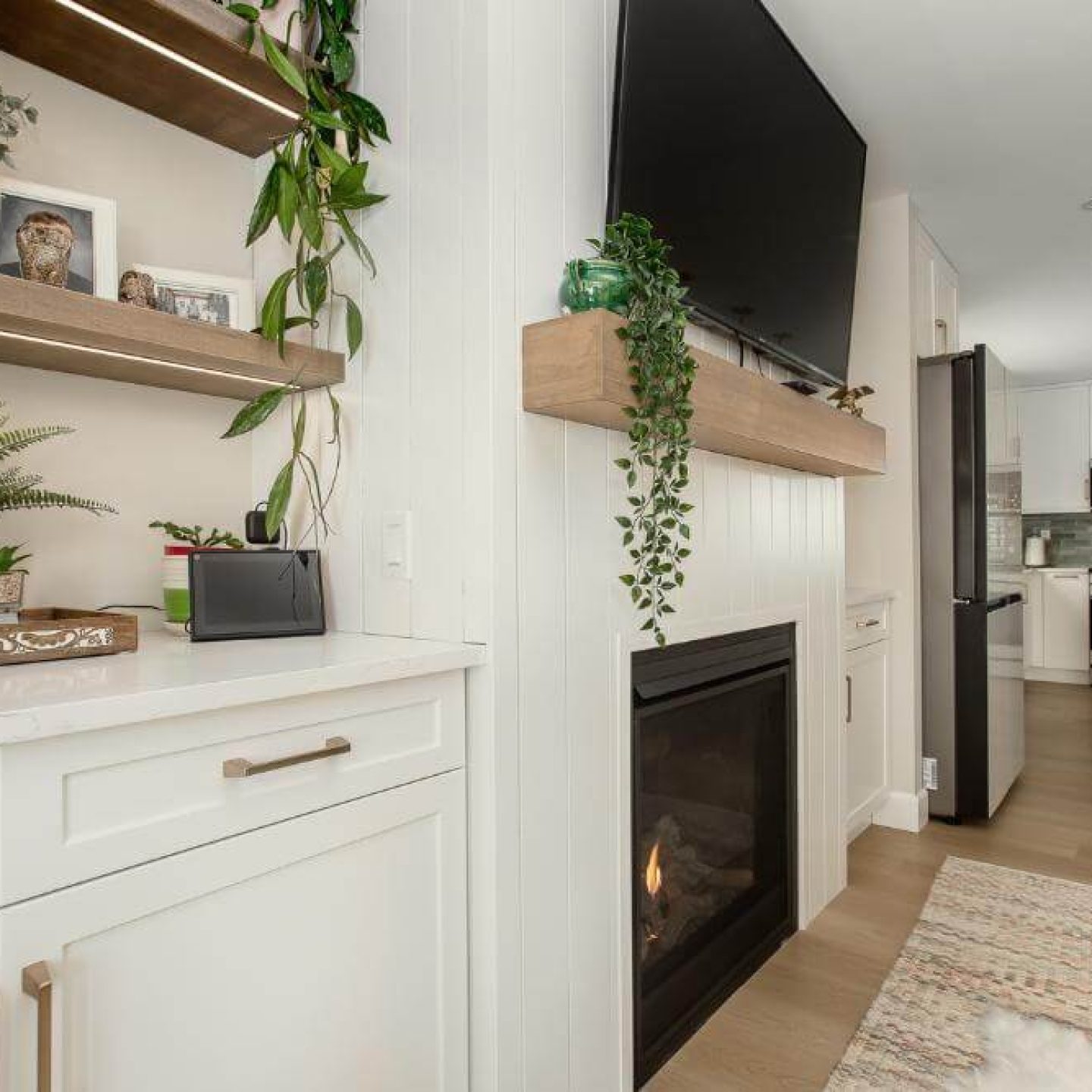 21 modern-living-room-shiplap-fireplace-floating-shelves-indoor-plants-white-cabinets